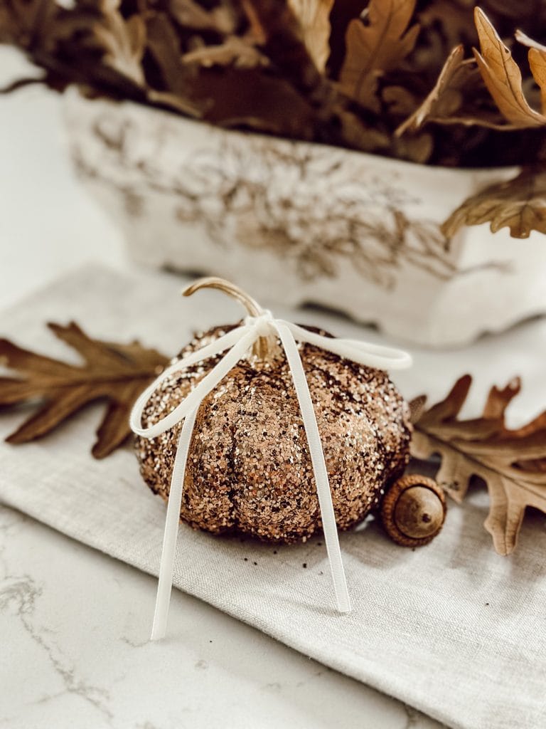 DIY glitter pumpkin with velvet ribbon and dried oak leaves.