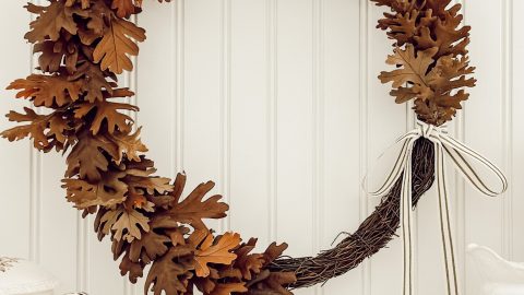 DIY rustic wreath for fall with dried oak leaves, grapevine wreath form, and ribbon.