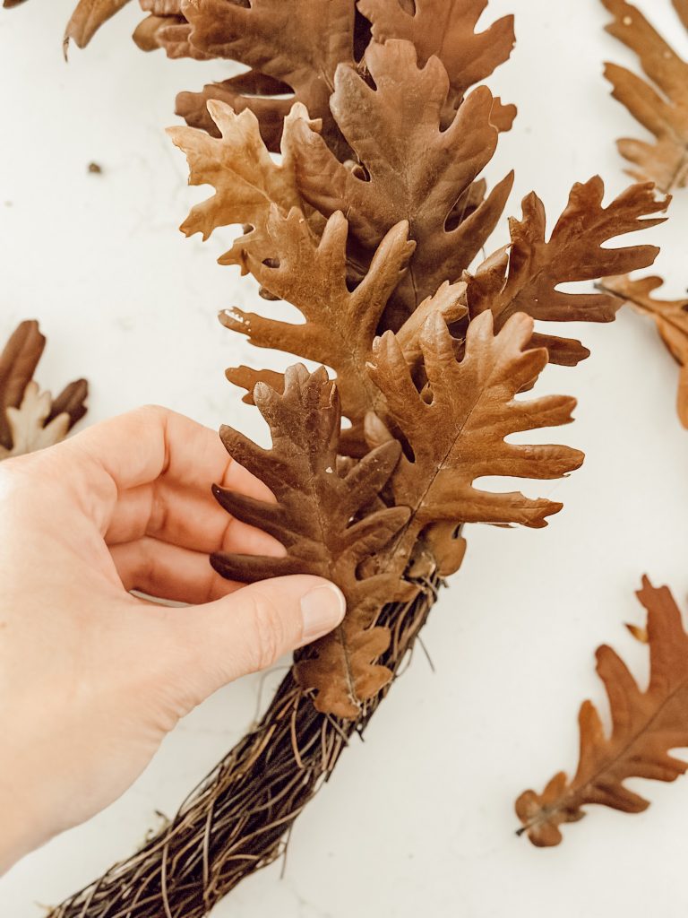 Attach dried oak leaves to grapevine wreath with a small dab of hot glue.