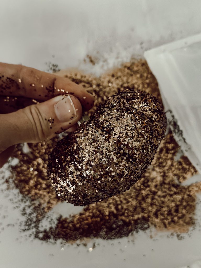 Add sparkle to a small gourd with brown glitter for glam fall decor.