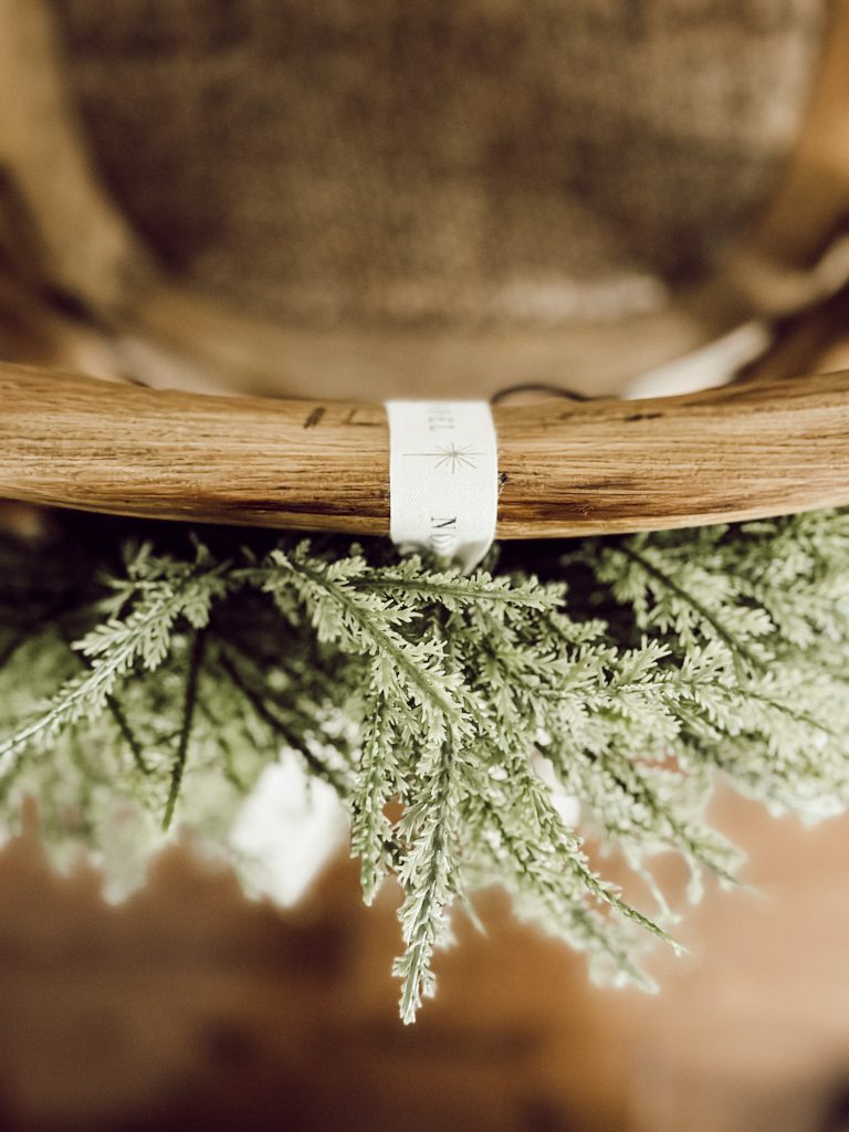 DIY Christmas wreaths on the back of kitchen counter chairs.