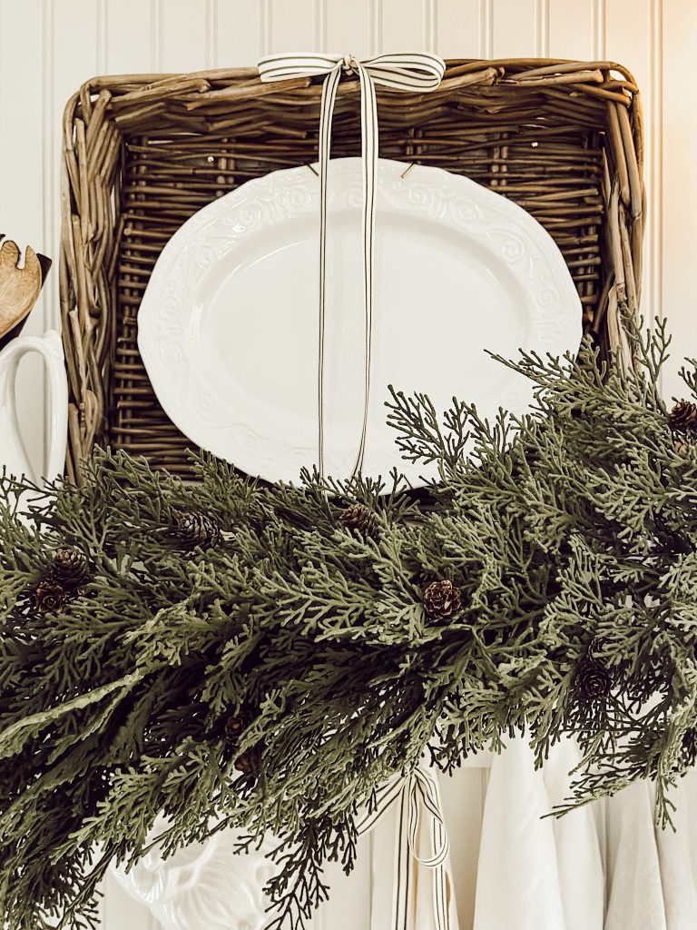 Faux greenery placed on an open kitchen shelf for the holidays.