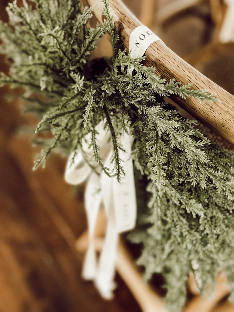Festive evergreen wreaths on kitchen counter stools for holiday decor.