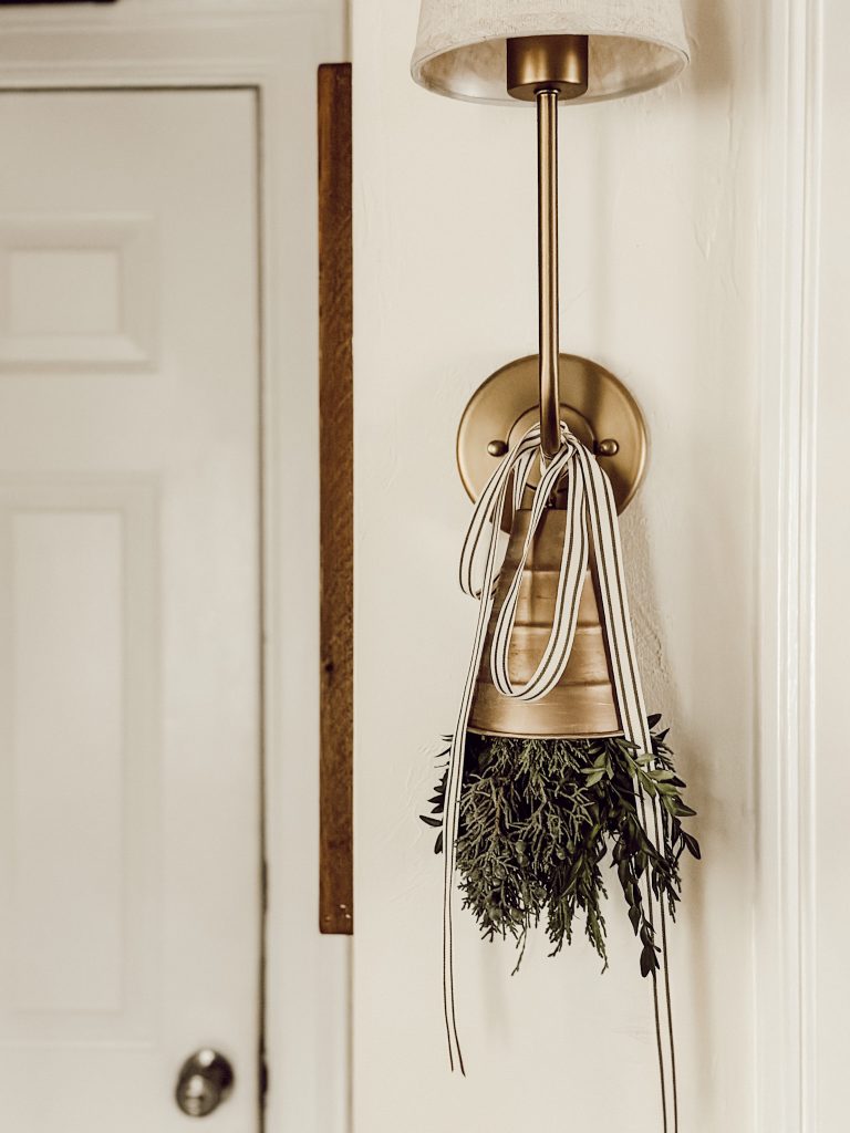 Christmas bell hanging from sconce in a cottage farmhouse style home.