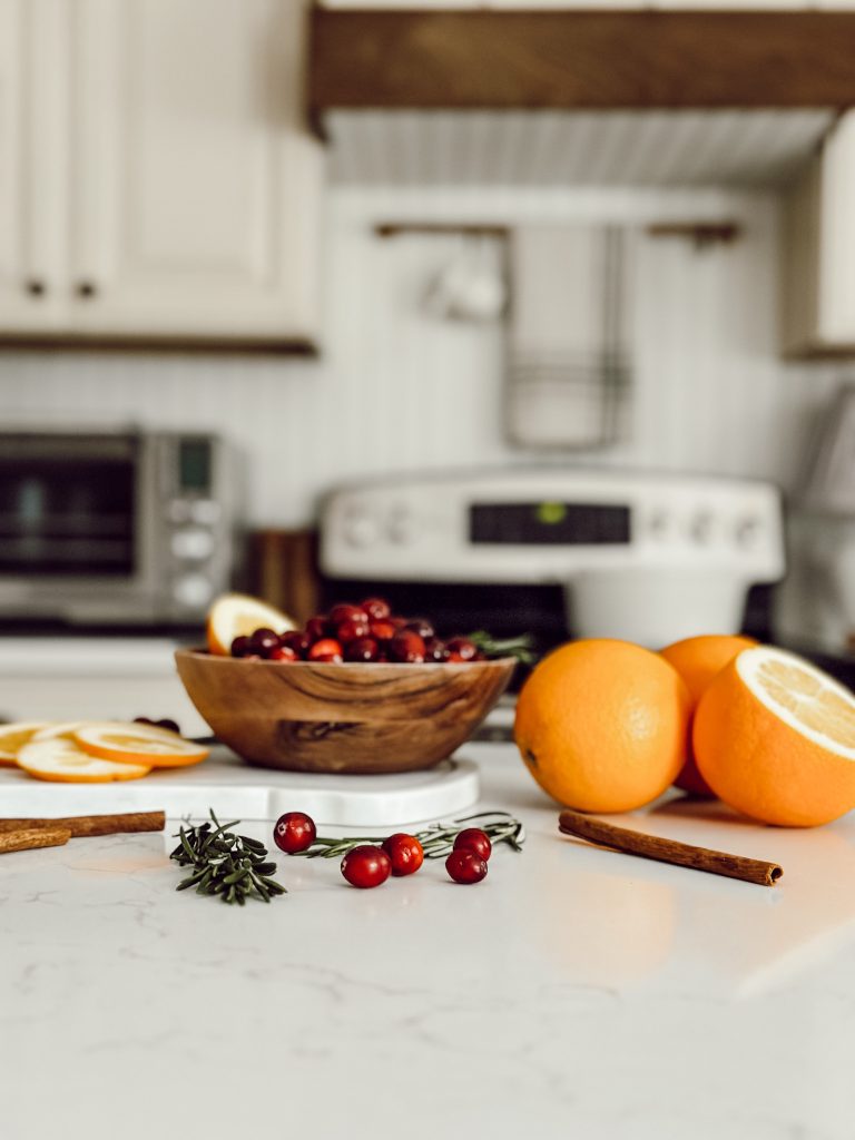 Natural simmer pot ingredients that include oranges, cinnamon, cranberries, and rosemary.