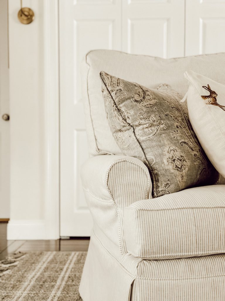 Cozy living room chair with throw pillows and an area rug to define the space.