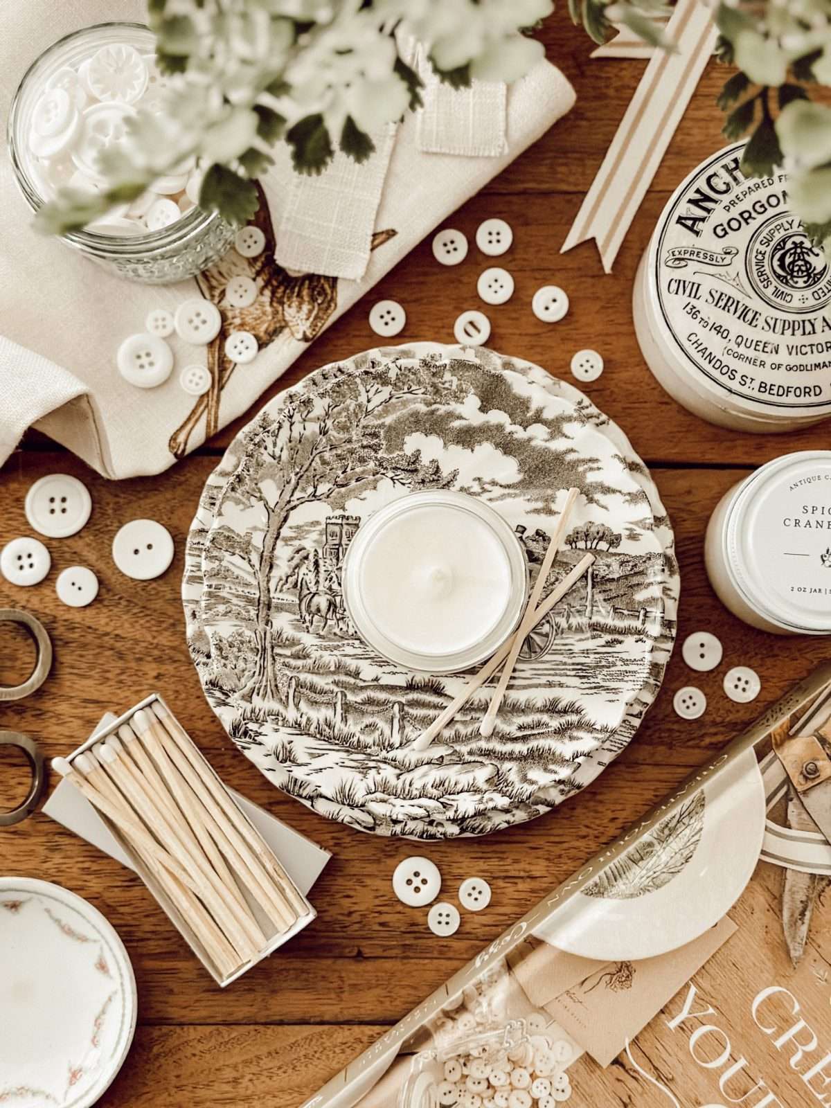 A flatlay of favorite items from Eleanor Rose Home like candles, books, and buttons.