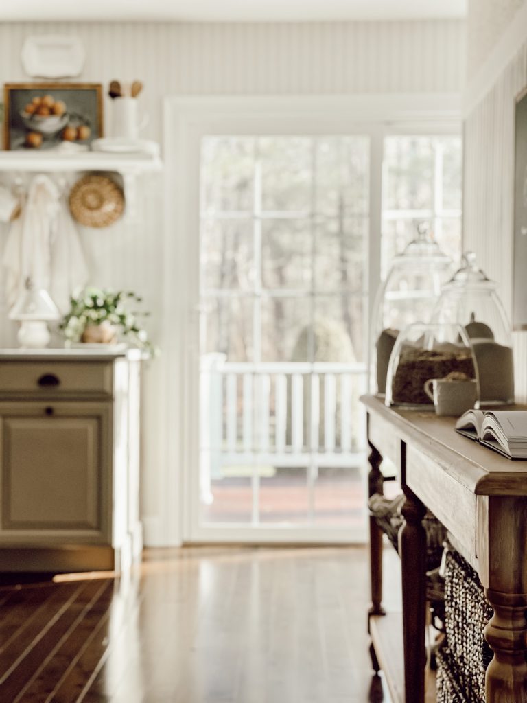 Wooden farmhouse table with baking supplies on display in clear canisters.