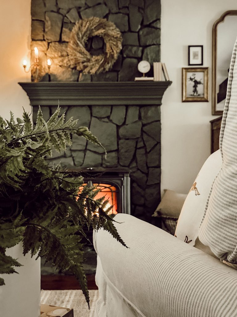 A green fireplace with mantel in a cozy country farmhouse home.