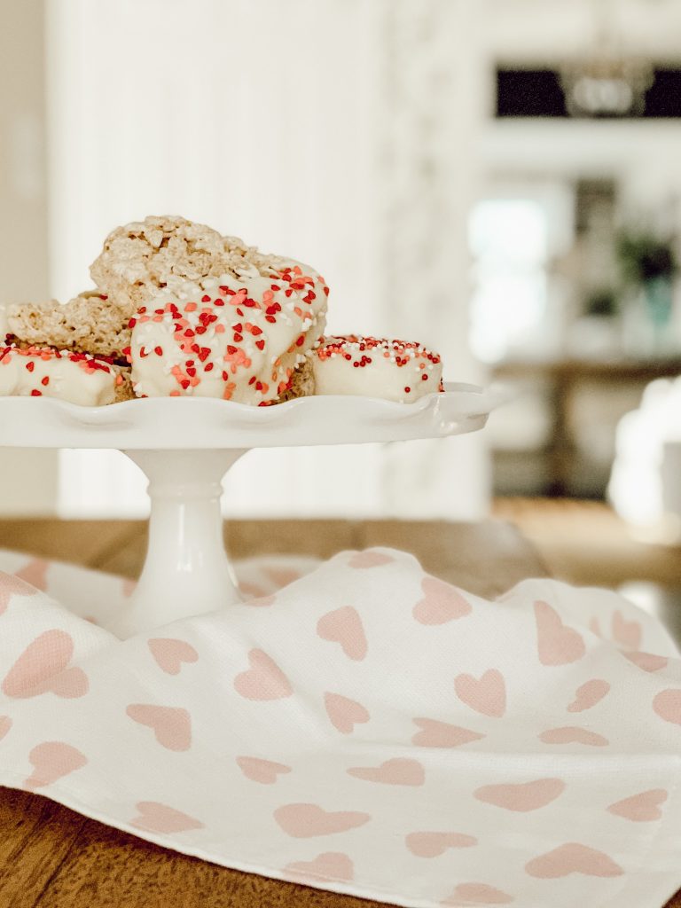 Heart shaped Rice Krispie treats covered in white chocolate and sprinkles.