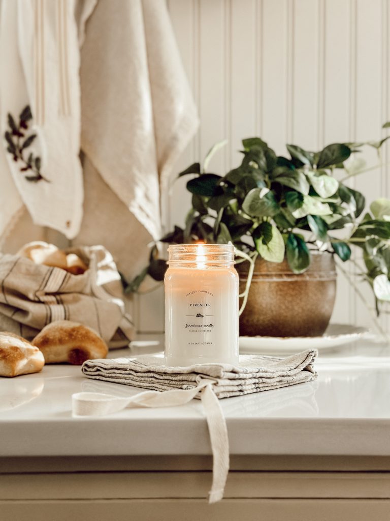 Non-Christmas winter decorating ideas with a cozy candle and faux greenery.