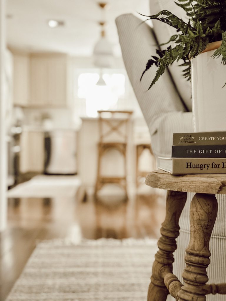 A wooden stool is the perfect end table for holding books, drinks, or plants.