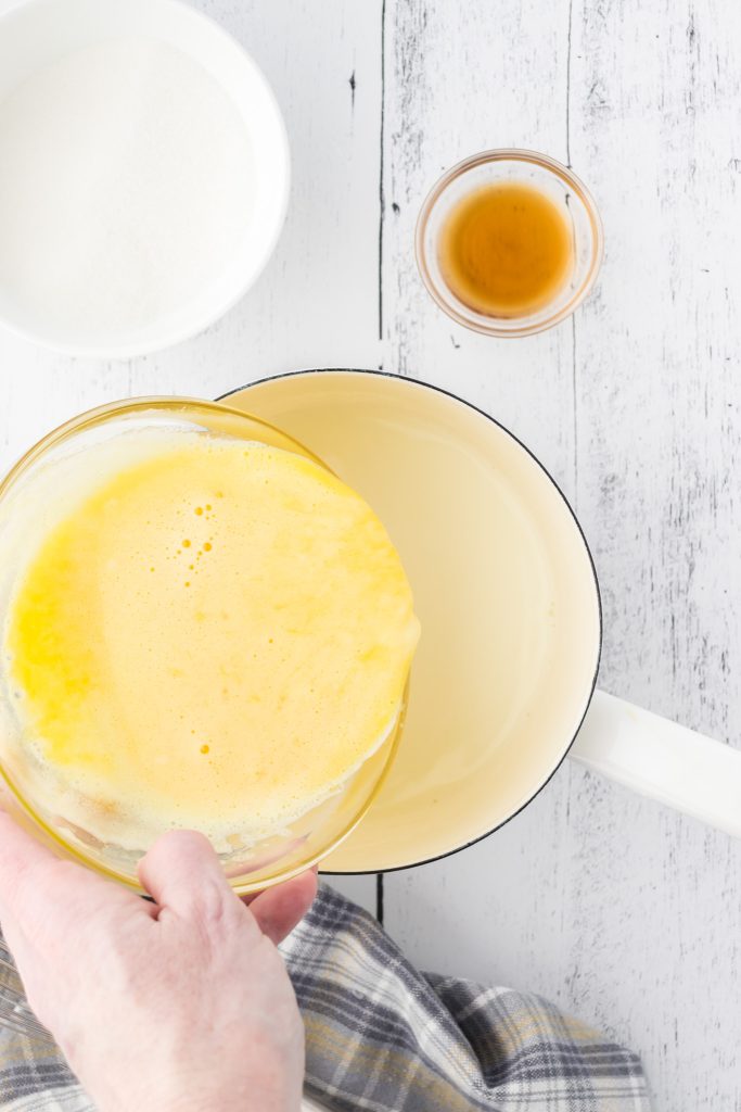 Add the tempered eggs to the hot milk to continue making the custard sauce.