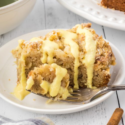 Apple cake with crumb topping drizzled with custard sauce.
