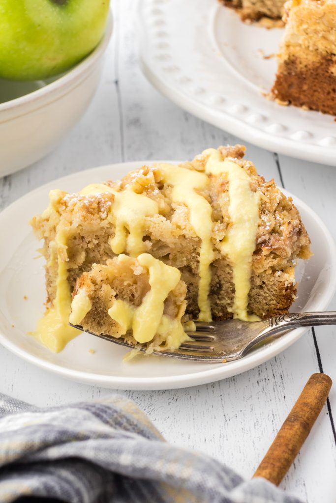 Apple cake with crumb topping drizzled with custard sauce. 