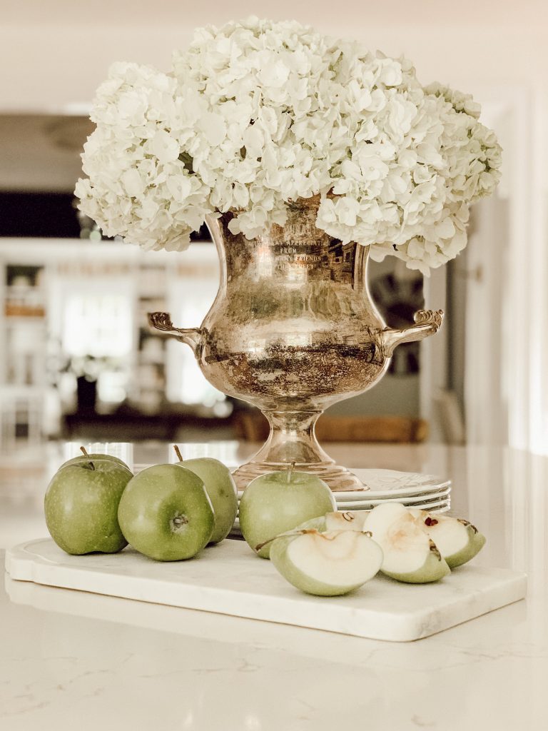 Hydrangea centerpiece for spring using white flowers and a vintage trophy.