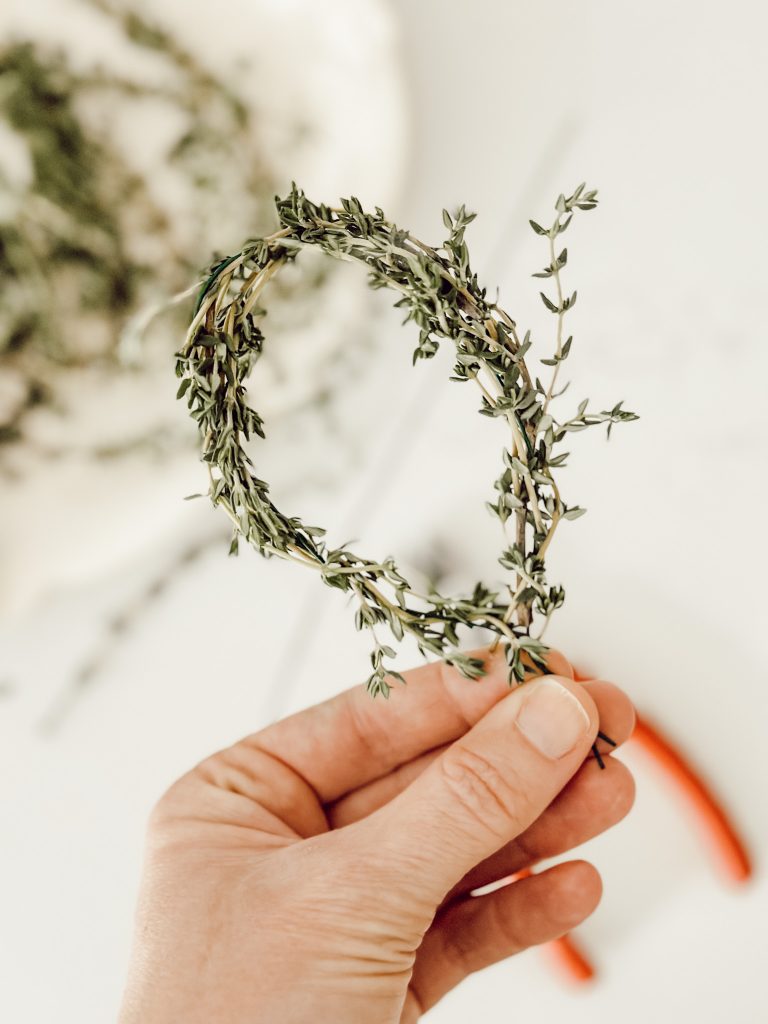 Bunny ear cake topper wrapped in fresh thyme sprigs for an Easter cake idea.