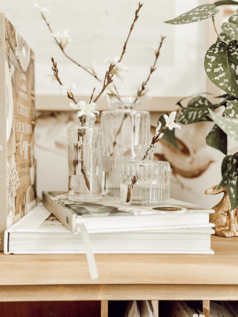 DIY home decor with a faux floral arrangement using bud vases, flowers, and acrylic water.