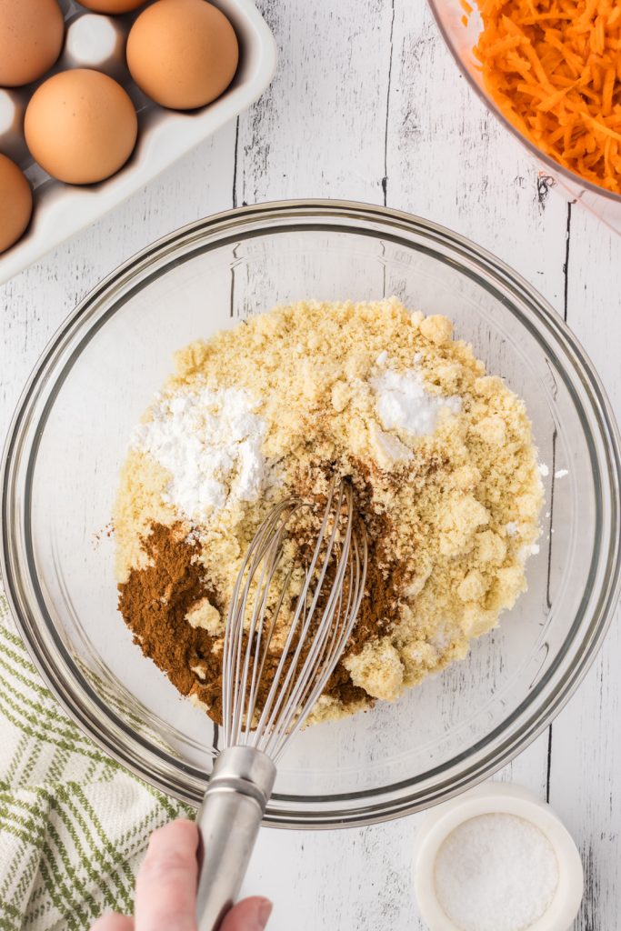 Mixing bowl with dry ingredients like almond flour, baking soda & powder, and pumpkin pie spice.