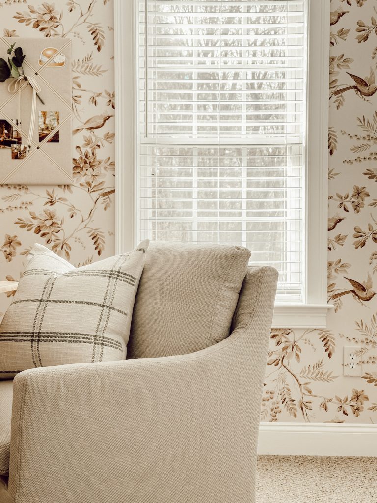 A functional home office with a comfortable desk chair and throw pillow.