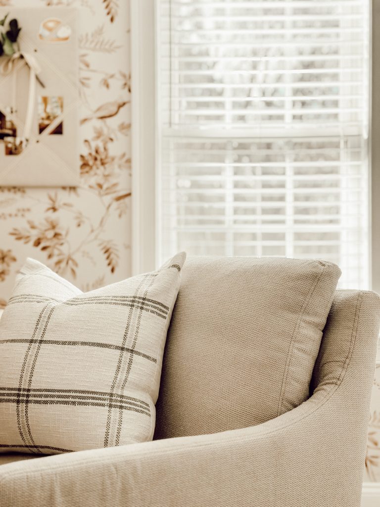 Office chair in a small home office with a decorative plaid throw pillow.
