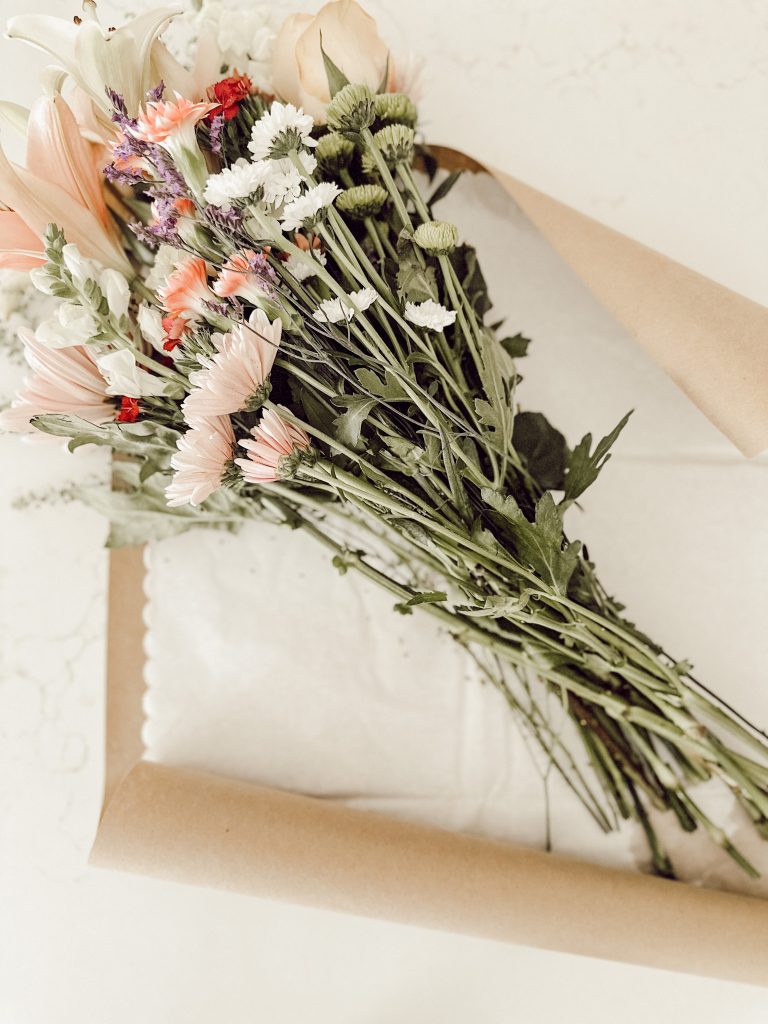 Fresh flowers that will be wrapped in brown paper and tissue paper.