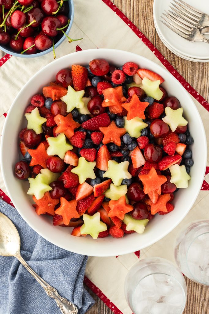 A delicious salad with star shaped watermelon & honeydew melon plus berries and cherries.