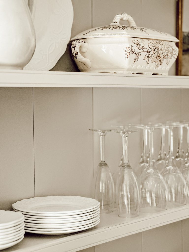 Functional kitchen decor styled on a hutch with vintage pieces and everyday dishes.