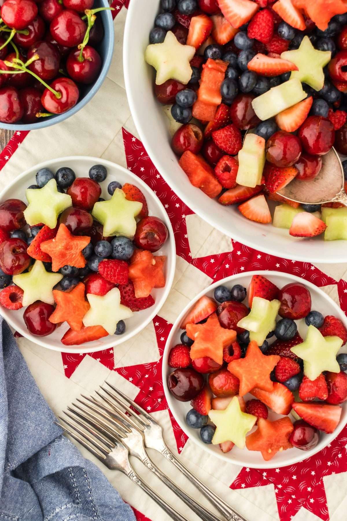 Independence Day fruit salad recipe with watermelon, honeydew melon, blueberries, strawberries, raspberries, and cherries.