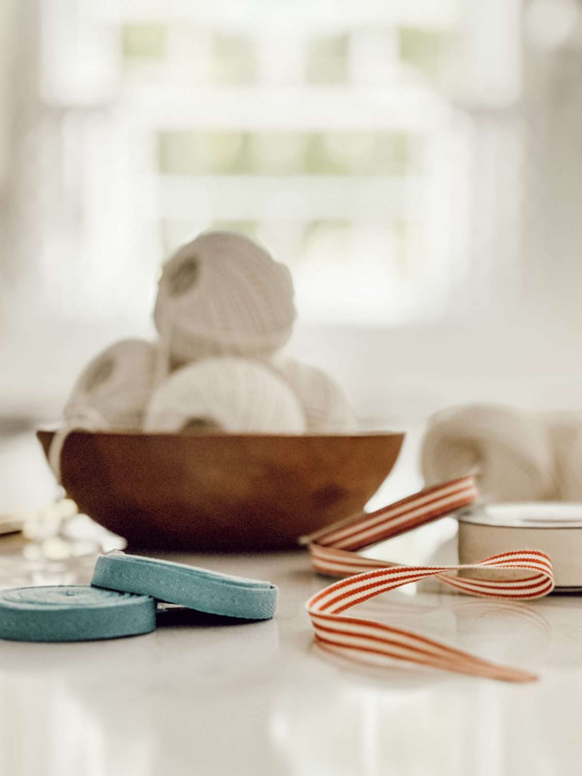 Kitchen twine, red ribbon, blue ribbon, and cream ribbon are the materials you'll need to make a patriotic garland.