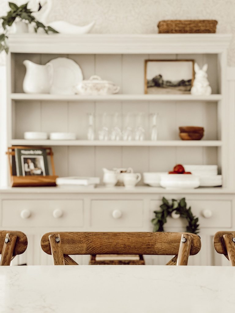 A neutral color scheme in a farmhouse kitchen with brown, cream, white, and green colors. 