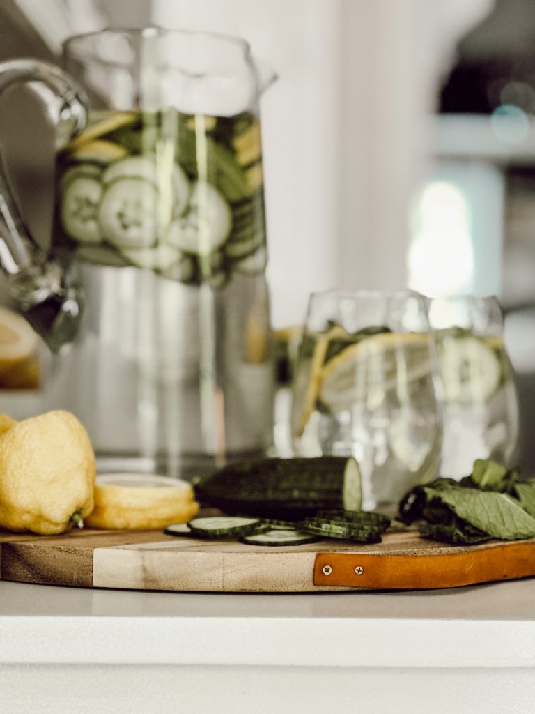 Sliced cucumber and lemon slices with sprigs of fresh mint in cold water.