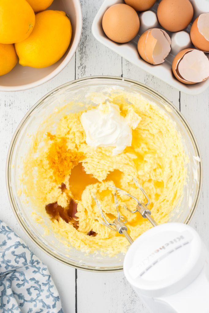 Sour cream and vanilla extract mixed together in a mixing bowl to make the cake batter.