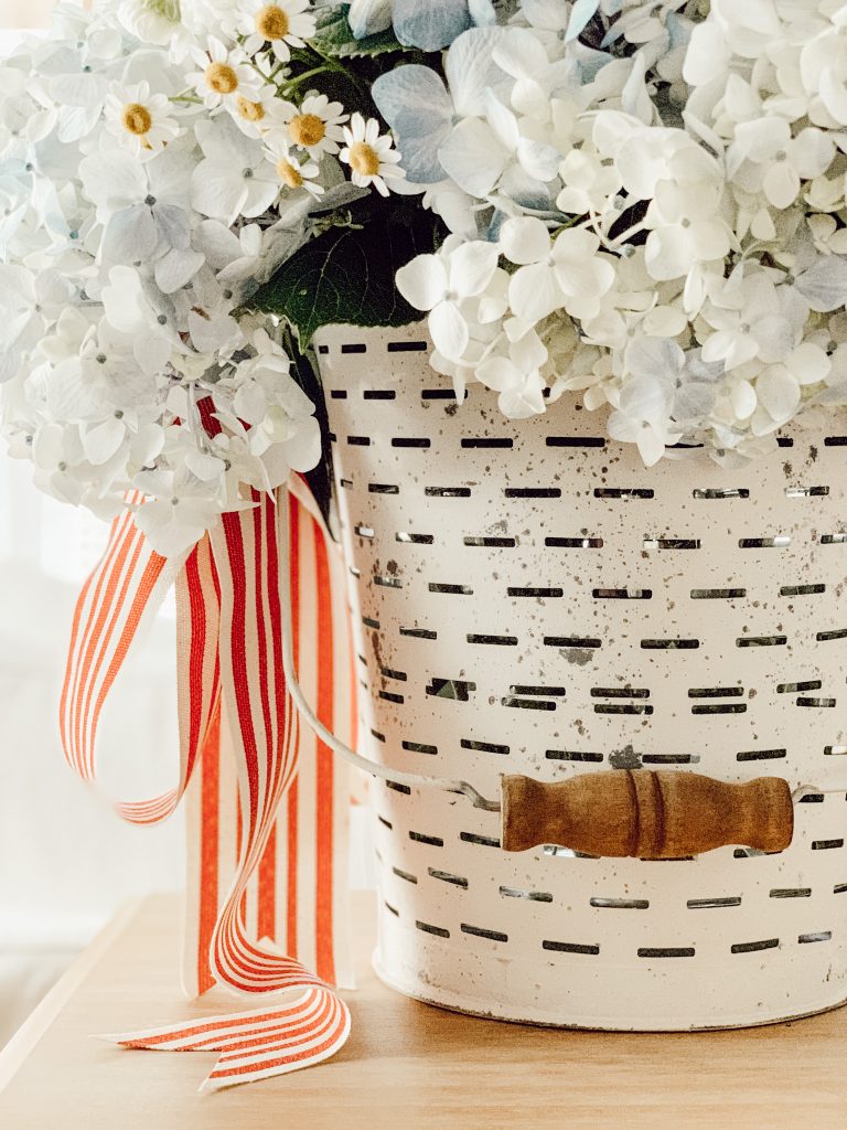 White bucket with red, white, and blue flowers for patriotic holidays.