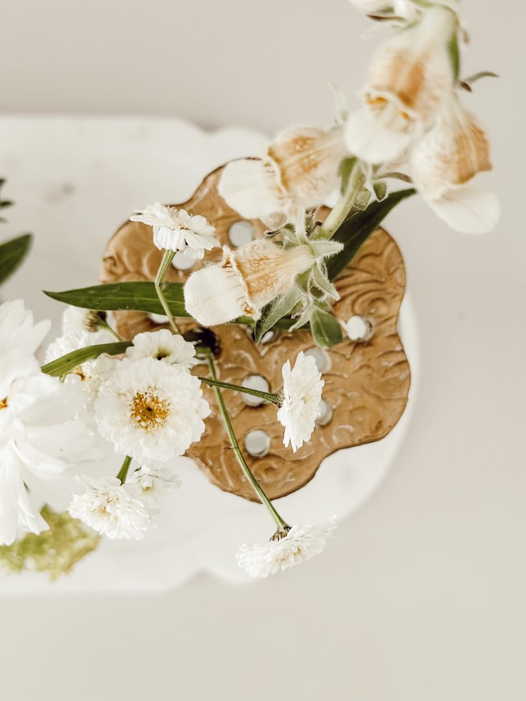 Mason jar with gold flower frog to hold fresh flowers in place.