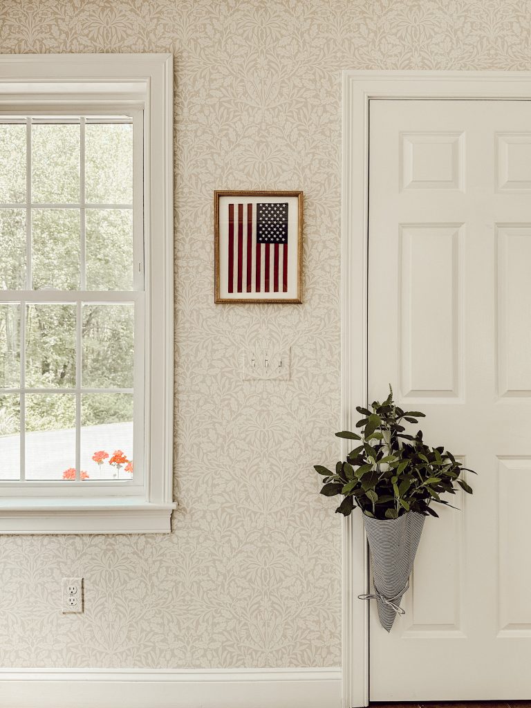 American flag hanging vertically in the entryway for patriotic holidays.