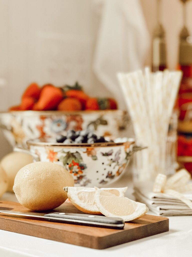 DIY lemonade drink station with colanders of fresh fruit and flavored syrups.
