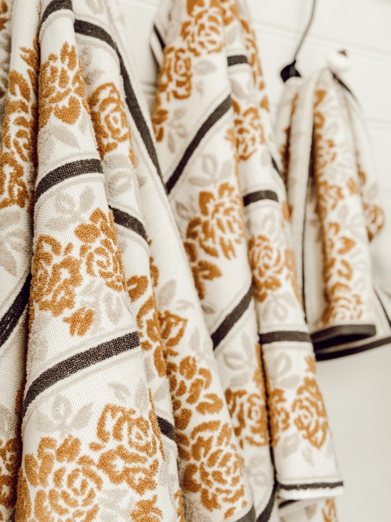 Beautiful Drew Barrymore bath towels in hanging in the bathroom.