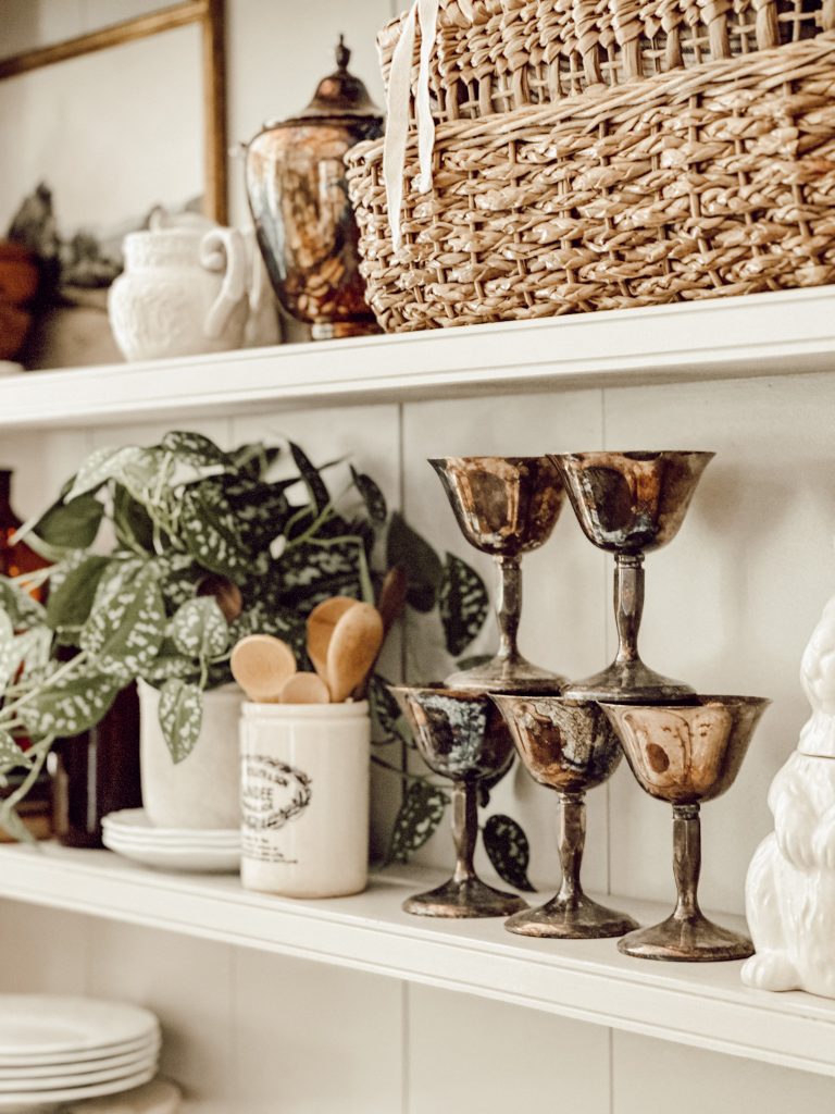 Cozy fall kitchen with warm metals, wicker baskets, and natural elements.
