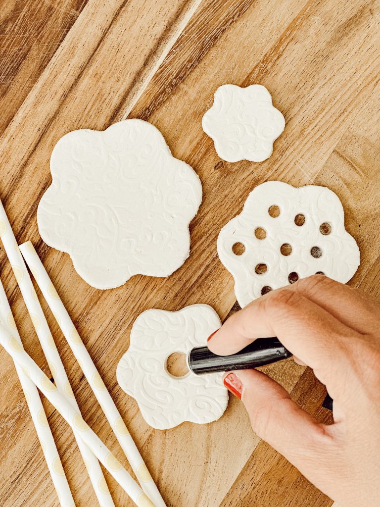 Create holes for the flower stems in the DIY flower frog with straws or pen caps.