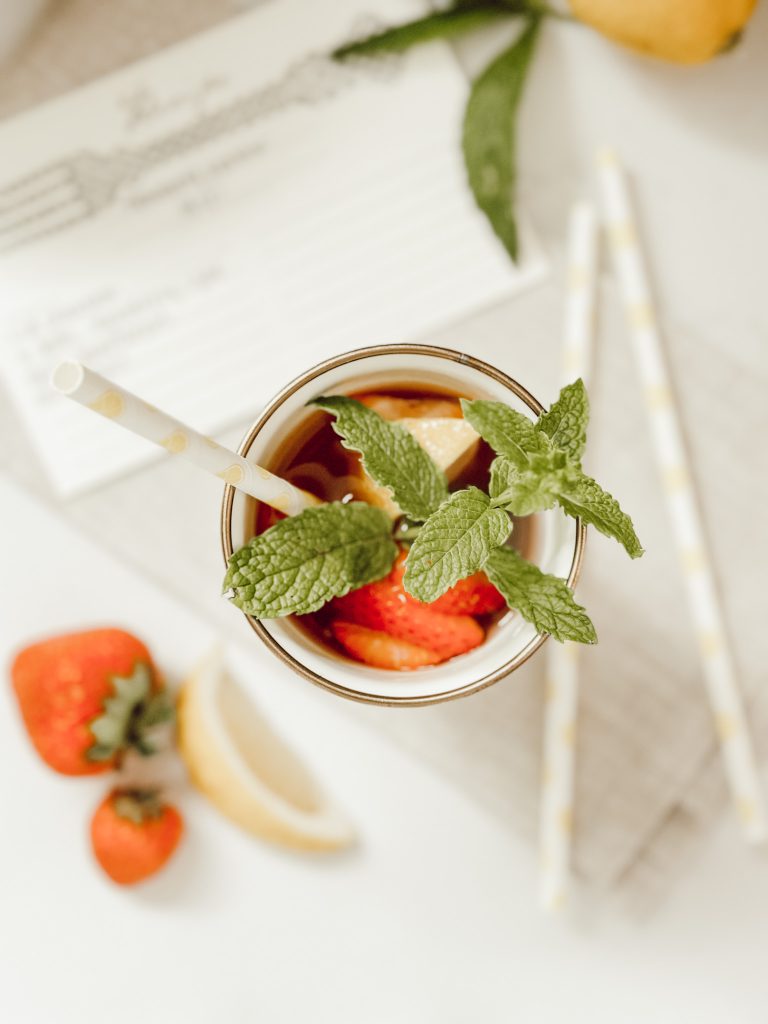 Strawberry lemonade with fresh mint leaves for garnish in a MacKenzie-Childs tumbler.