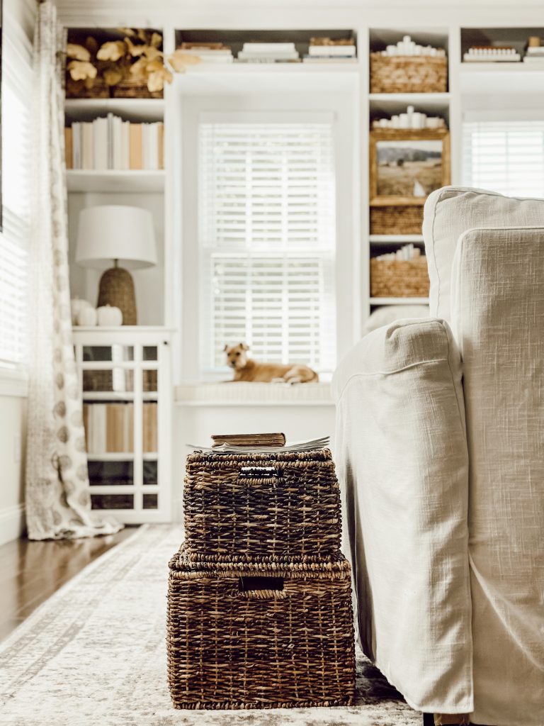 Wicker baskets on bookshelves in family room for cozy fall vibes.