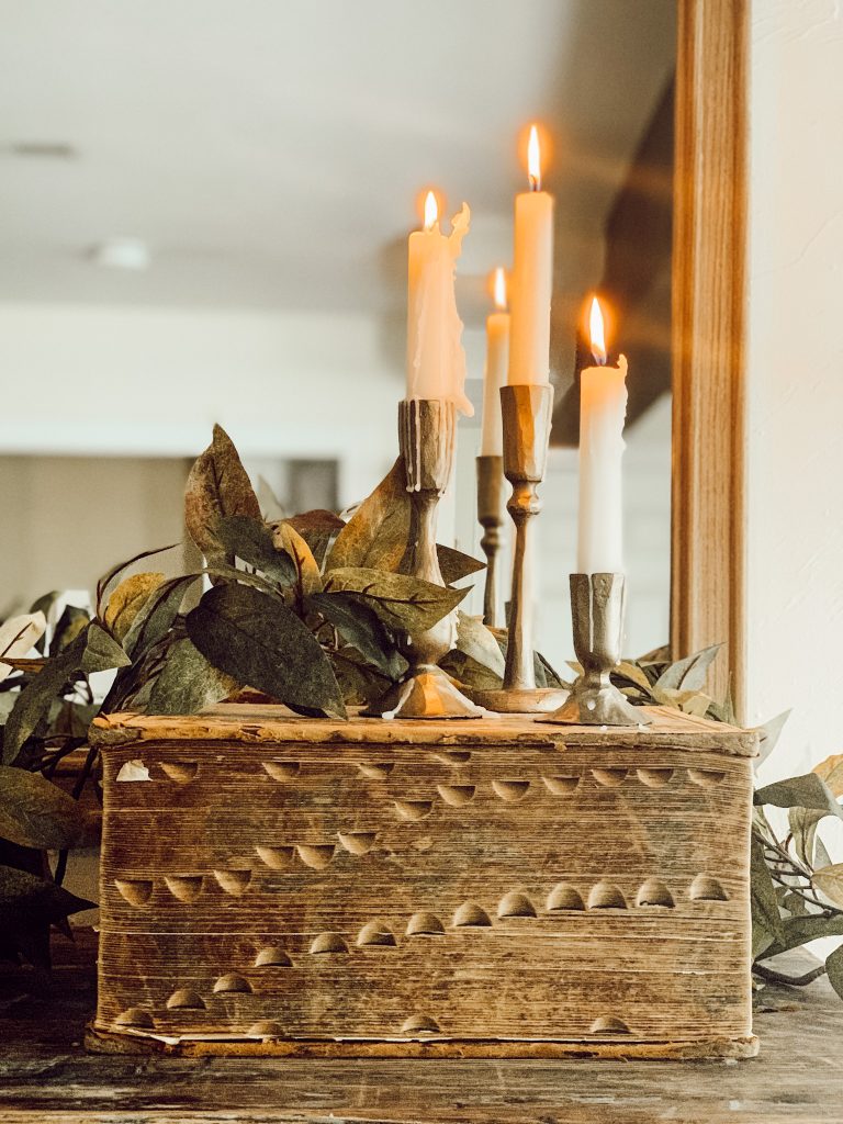 Set of 3 candles on a vintage book for collected fall decor.