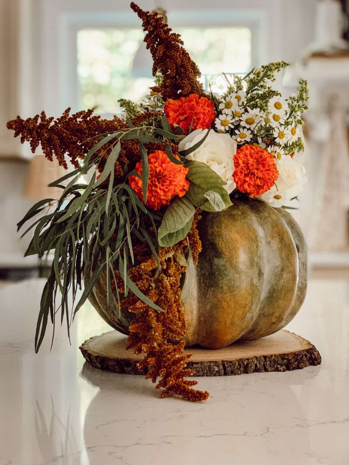 DIY fall pumpkin flower arrangement using a cinderella pumpkin and fresh flowers.
