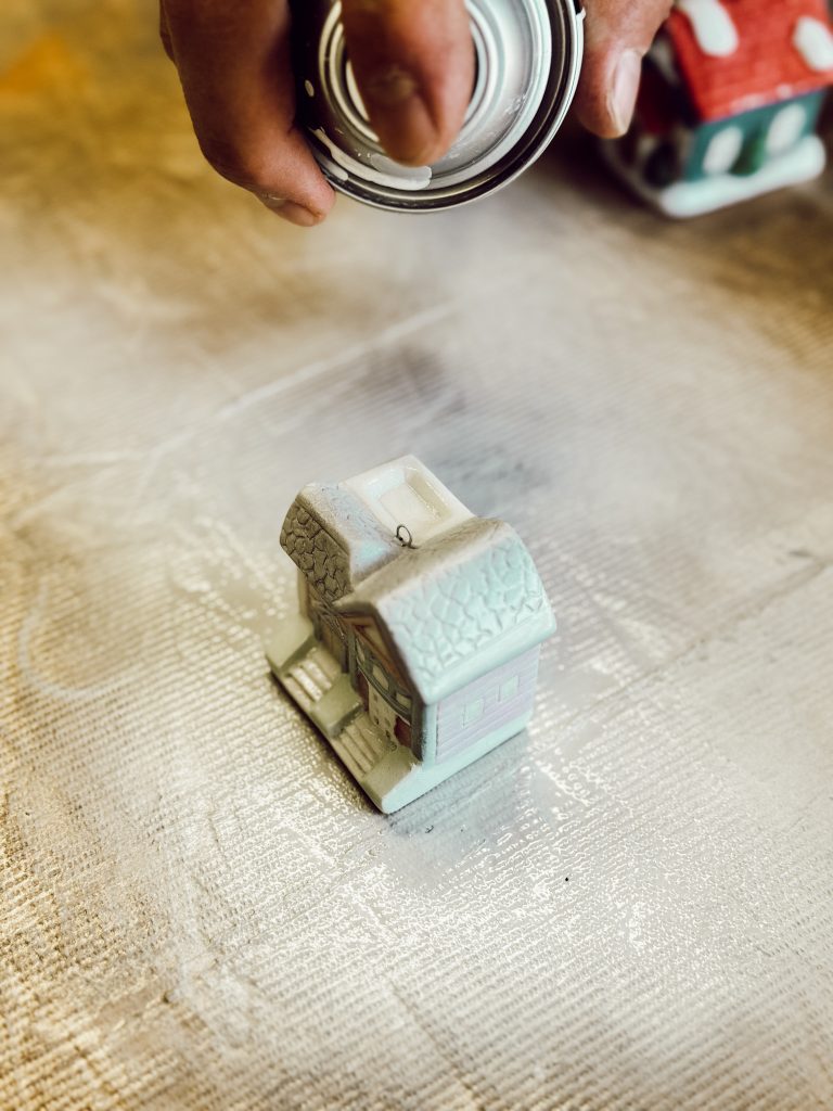 Apply spray paint in an even coat onto the ceramic houses to transform them into candy jar toppers.