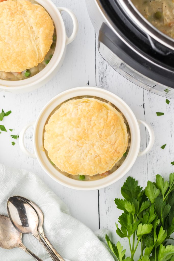Flaky puff pastry crust on small bowls of homemade chicken pot pie.
