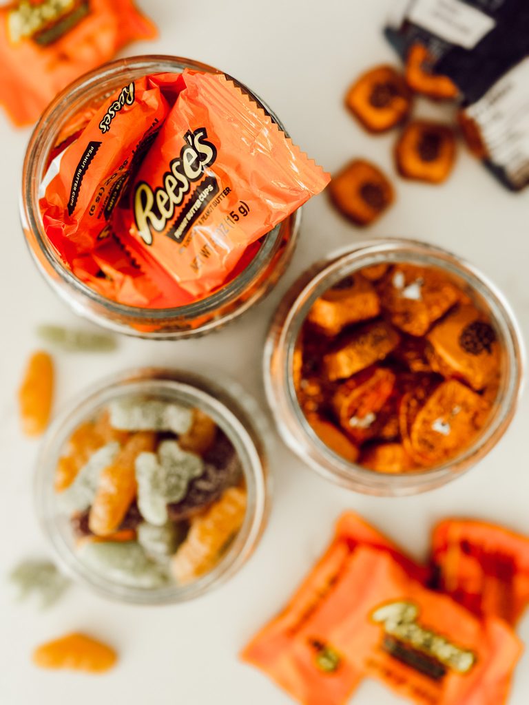 Glass canisters filled with assorted Halloween candy to complete the candy jar DIY.