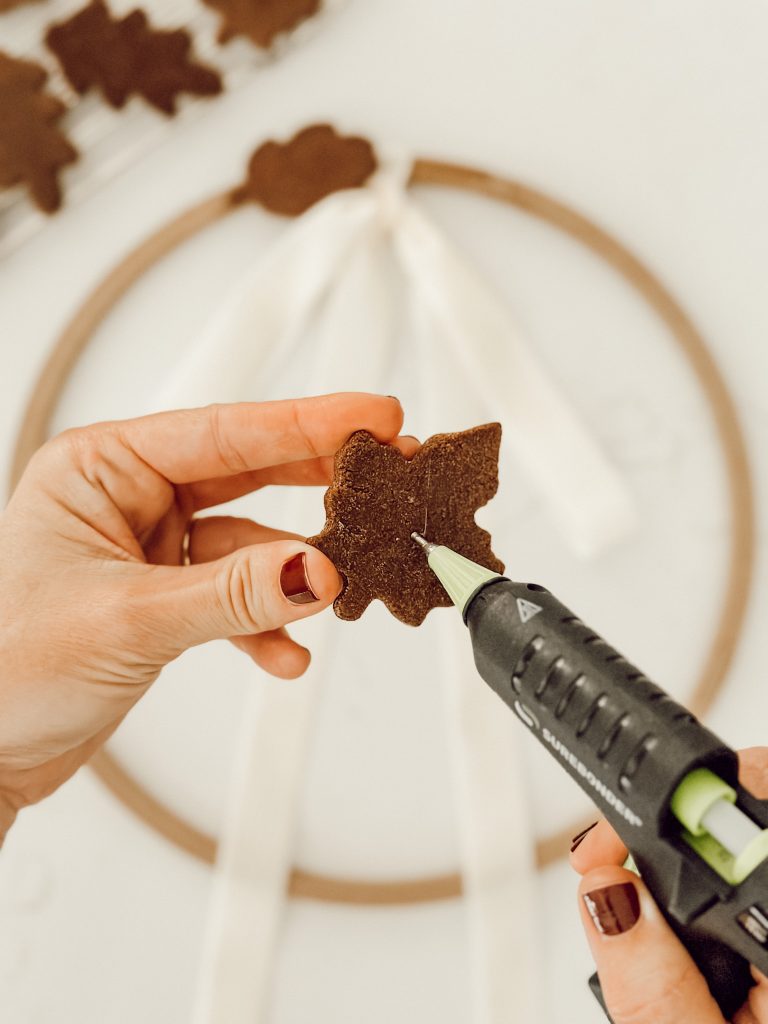 Hot glue gun to add salt dough leaves to wreath for fall DIY project.