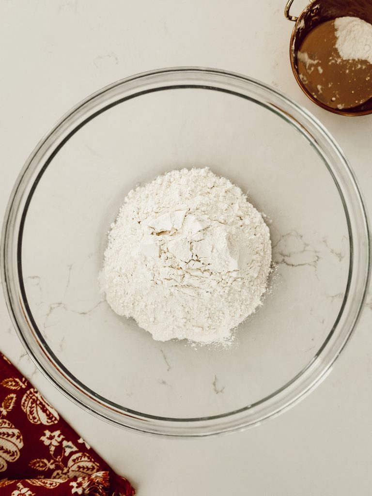 Add a cup of all-purpose flour to a large mixing bowl for the base of the salt dough recipe.