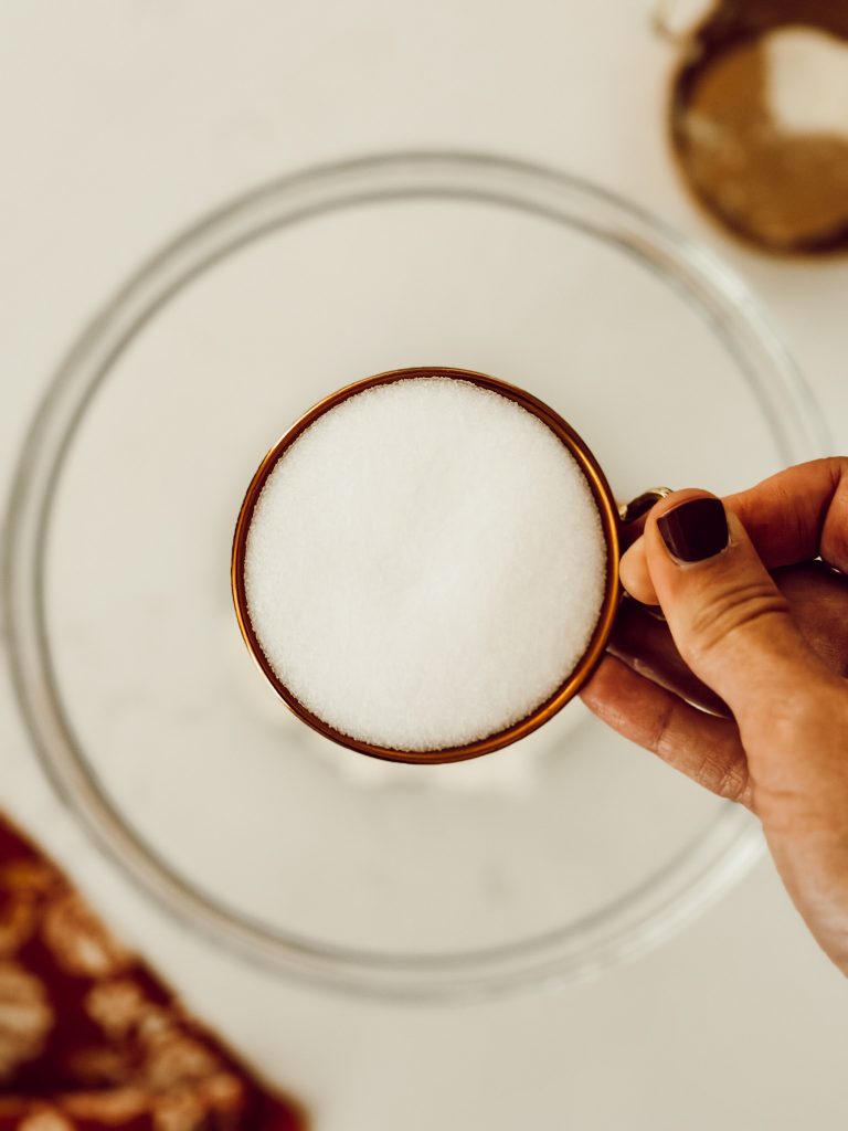 Measuring cup full of table salt to add to the pumpkin craft dough dry ingredients.